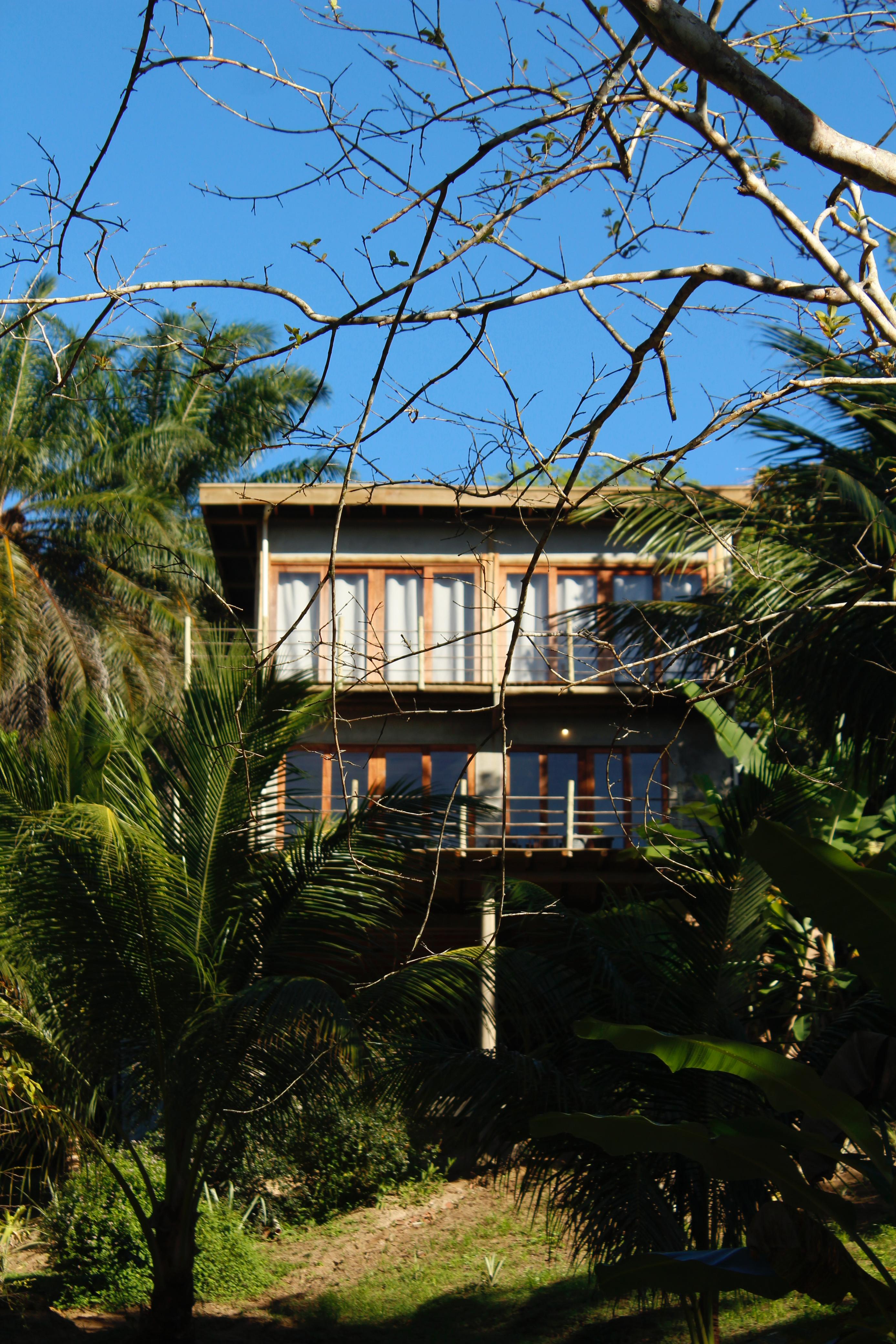 Refúgio Pachamama main house exterior among palm trees