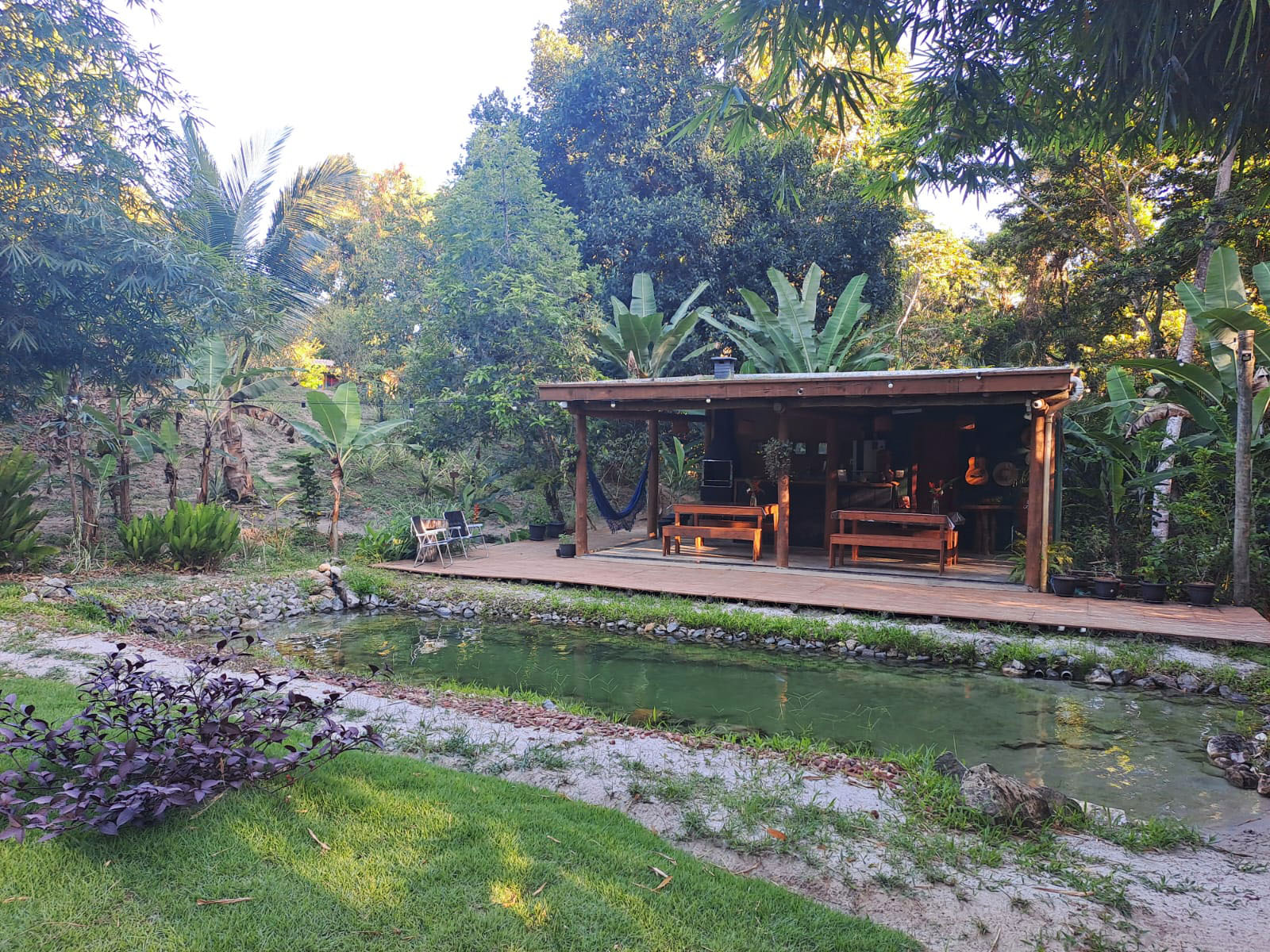 Refúgio Pachamama communal lounge by the natural pool at dusk