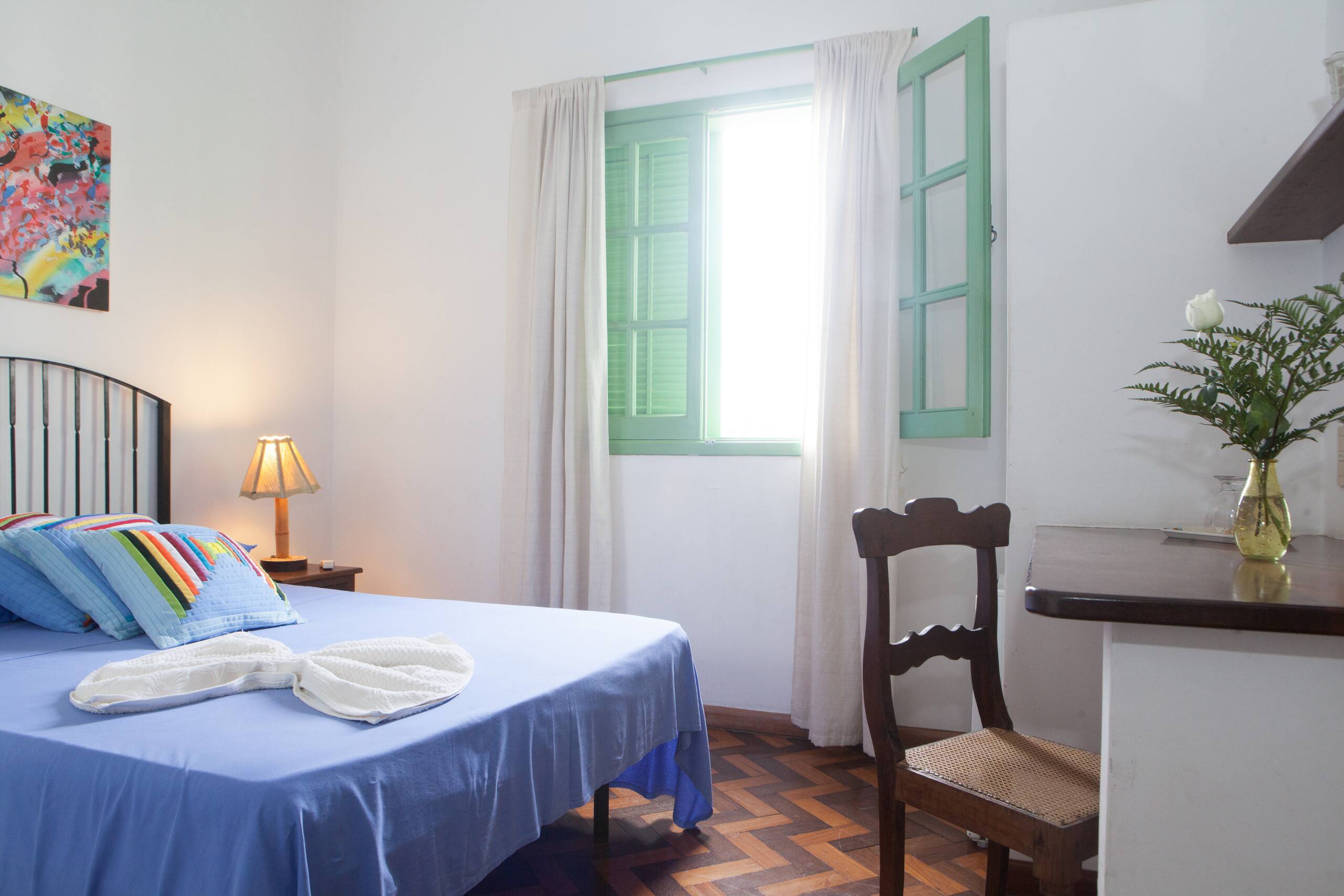 Casa Zelina bedroom with blue bed and green windows